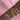 A wrist adorned with five bracelets on a pink satin background: two beaded charm bracelets in silver and gold featuring enamel heart pendants, and three sleek bangles in gold, rose gold, and silver, each with repeating heart motifs engraved around the band.