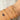 A wrist adorned with delicate silver and gold chain bracelets featuring small charms and gemstones, creating a sparkling, elegant look against a neutral background.