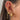 Gold ear stack with pink accents featuring a crescent moon charm, butterfly studs, dainty chains and heart-shaped drops – feminine jewellery look for curated piercings