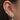 Close-up of an ear with multiple silver earrings on a blurred background