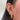 Close-up of an ear adorned with multiple gold and diamond earrings, including hoops and studs, set against smooth, dark hair, conveying elegance and style.