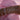Close-up of a forearm adorned with nine delicate bracelets, featuring pearls and charms, set against a soft pink fabric background. Elegant and luxurious tone.