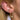 Gold huggie hoop earrings with moon and star charms encrusted with cubic zirconia, styled with a red heart charm and lightning bolt stud on blonde hair