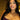 Model wearing crystal cross pendant necklace with gold chain, styled with plum strapless top and glam makeup