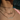 Close-up of a woman's neck showcasing three layered gold necklaces: a choker with clear stones, a name necklace reading "Natalia" in a cursive script, and a third necklace featuring the name "Melissa" in Arabic script.