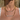 Person wearing gold necklaces with names on a lace top.