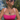 Woman in a pink bikini top standing in water with a scenic background