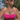 Woman in a pink bikini top standing in water with a scenic background