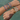 Close-up of a wrist with multiple colorful bracelets against a blurred natural background
