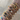 Stacked gold bangle bracelets with colourful hearts, floral charms, Roman numerals, and crystal detailing — trendy arm candy jewellery styling.