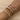 A stack of seven vibrant and elegant bracelets on a wrist, featuring a mix of gold-toned chains, white pearls, dainty floral beaded designs in pink and blue, a heart charm, a gold cross charm, and crystal accents, all displayed against a soft beige background.