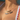 A woman in a pool wearing two balloon-style name necklaces. The top gold necklace spells “NATALIA” and the bottom silver necklace spells “BINKY BELLE.” Water droplets glisten on her skin, and she is wearing a white swimsuit with red scalloped trim and a blue floral pattern. Sunlight casts soft reflections across her chest and jewellery.