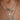 Three layered necklaces on a neck. Top necklace spells "NATALIA" in gold, middle has a heart-shaped opal, and bottom also spells "NATALIA" in rhinestones.