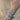 Hand wearing multiple bracelets and rings on a tiled floor background