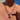 Close-up of a person wearing a gold necklace with a heart-shaped pendant against a blue sky.