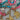 Set of colorful beaded bracelets with gold charms on a textured surface