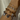 Multiple bracelets with heart charms on a wrist against a neutral background