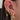 Close-up of an ear with multiple gold and diamond earrings.