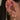 Close-up of an ear with multiple gold earrings including moons, stars, and chains.