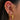 Close-up of an ear with multiple gold and gemstone earrings.