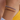 Three beaded bracelets in gold, silver, and pink on a wrist with a blurred background.