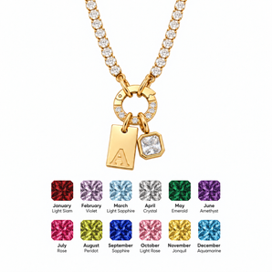 A gold-toned initial necklace with a charm displaying the letter 'A', shown on a white background with twelve color options for the initial charm at the bottom.