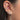 Close-up of an ear with multiple opal diamond earrings