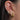 Close-up of an ear with multiple gold and diamond earrings.