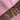 A wrist adorned with five bracelets on a pink satin background: two beaded charm bracelets in silver and gold featuring enamel heart pendants, and three sleek bangles in gold, rose gold, and silver, each with repeating heart motifs engraved around the band.
