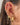 Close-up of an ear with multiple gold earrings and accessories.