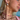 A woman wearing layered gold and silver jewellery, including silver hoop earrings with pink bow and white heart charms, and gold necklaces featuring pink beaded flowers, a crystal heart, a "Binky Belle" nameplate, and a large flower-shaped pendant. She is dressed in a pink top and looking away from the camera.