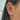 A woman's ear adorned with multiple gold and diamond earrings, including hoops, studs, and a heart-shaped pendant, conveying luxury and elegance.