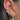 Close-up of an ear with multiple gold and diamond earrings.