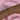 A wrist stacked with multiple delicate silver-toned bracelets, featuring pearls, crystals, and charm designs like crosses, stars, butterflies, and hearts, against a soft pink satin background.