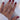 A detailed view of a woman's hand featuring a gold ring, emphasizing the ring's shine and the hand's graceful posture.