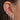 Close-up of an ear with multiple silver earrings