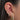 Close-up of an ear with multiple gold and diamond earrings.