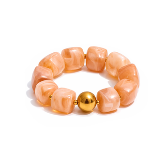 Bracelet with beige-colored beads and a gold bead on a white background