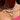 Layered silver and pearl necklaces featuring a “Binky Belle” nameplate, 11:11 charm, crystal letter "E", and a silver heart and hands pendant, styled over a pink ribbed top.