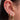 Close-up of an ear adorned with multiple gold earrings, featuring stars and diamonds. The intricate designs convey elegance and sophistication.