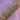 A forearm adorned with numerous gold and silver bangles, featuring heart and star motifs, against a pink fabric background, exuding elegance and style.