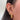 Close-up of an ear adorned with multiple gold and diamond earrings, including hoops and studs, on dark hair, showcasing a trendy and elegant style.