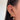 Close-up of an ear adorned with multiple gold and diamond earrings, including hoops, stars, and a heart-shaped dangle. The tone is stylish and elegant.