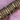 Stacked rose gold and gold bangles with Roman numerals, crystal details, heart charms, and floral designs styled on a pink satin background – luxury arm candy stack.
