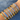Ten bangle bracelets with star and sun motifs in gold and silver, adorned with crystals, arranged on a wrist. Blurred water droplets form the background.