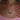 A woman with pink-painted nails and a delicate necklace, highlighting her fashionable appearance.