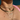 Close-up of necklaces with cross pendant and pink top against a blue background.