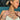 Woman with blonde hair in a bun wearing layered gold and silver necklaces, including a “Melissa” name necklace, heart charm necklace, and floral pendant; she also wears stacked bracelets, a delicate silver hand chain, and mixed-metal rings while relaxing by a pool in sunlight.