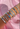 Multiple bracelets on a wrist against a pink fabric background
