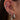 Close-up of an ear with multiple silver earrings